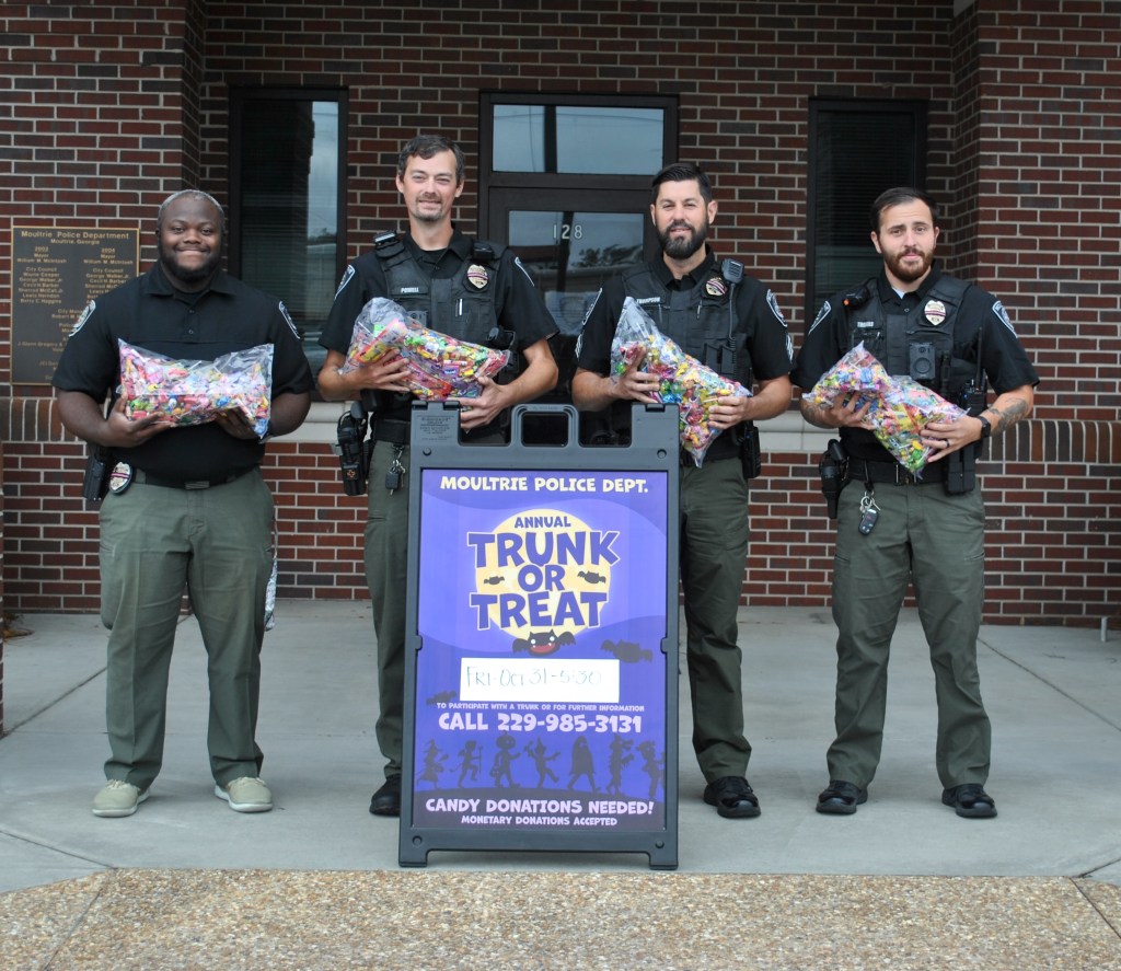 Officers with trunk or treat sign