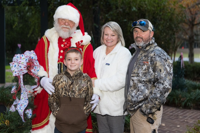 Love Lights tree lighter Carson Hayden with parents and Santa